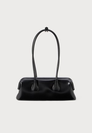 Sac à main en cuir noir avec deux poignées allongées, une texture lisse et une base arrondie, ornée d'accents décoratifs sur les côtés.