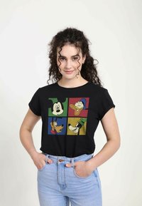 Camiseta negra con un estampado gráfico de personajes de dibujos animados: Mickey, Donald, Pluto y Goofy en cuadros de colores. Mangas cortas, corte relajado.