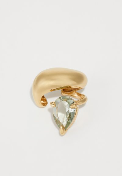 Gold-tone ring featuring a smooth, rounded design with a textured band. The ring is accented by a pear-shaped, light green stone.