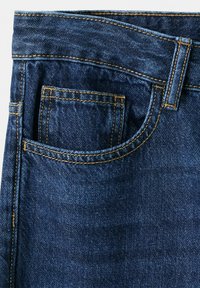 Poche de jean en denim bleu foncé avec une double couture orange visible et une petite poche intérieure pour monnaie sur le côté avant droit.