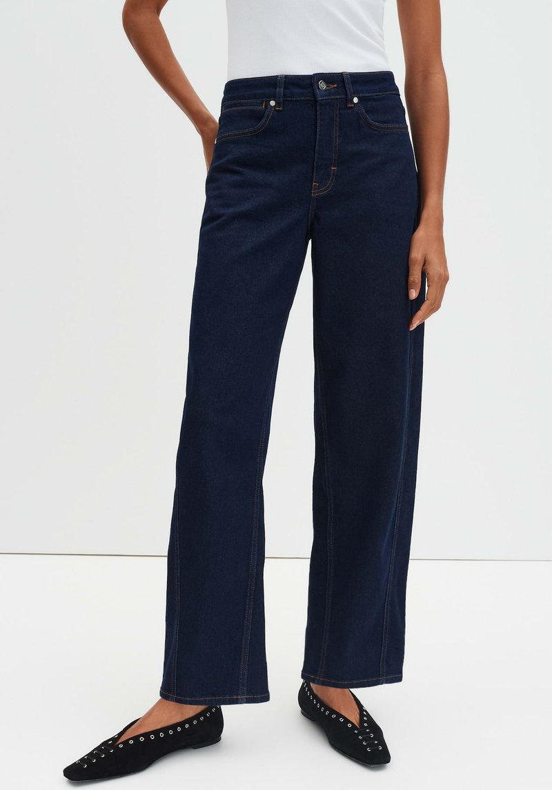 Jeans a gamba larga blu navy con vita alta, cuciture arancioni a contrasto, cinque tasche e chiusura con bottone. Tessuto denim liscio.