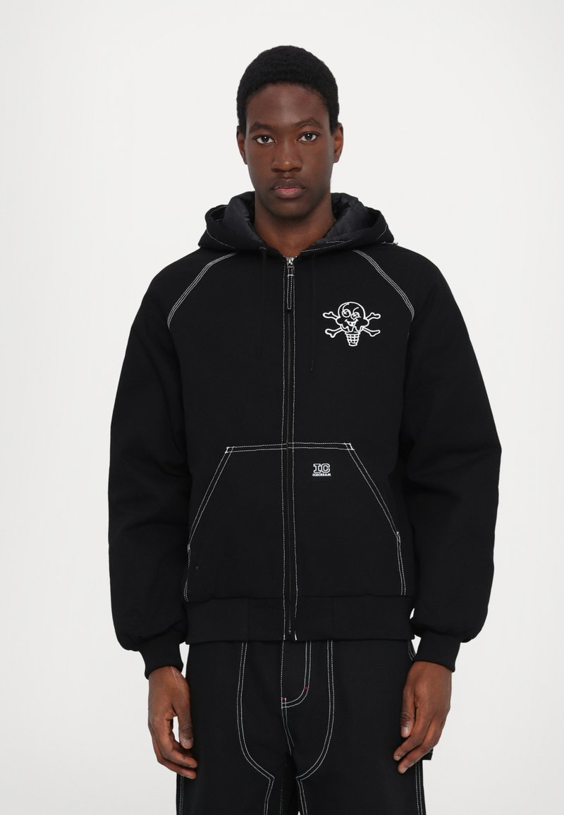 Black hooded sweatshirt made of fleece with white stitching. Features an ice cream skull graphic on the chest and front pockets.