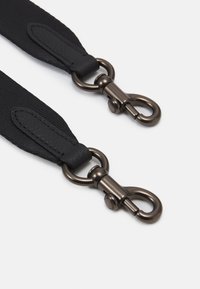 Cinghia nera in nylon con dettagli in pelle e clips in metallo color bronzo. Presenta una superficie texturizzata e cuciture rinforzate per garantire durata.