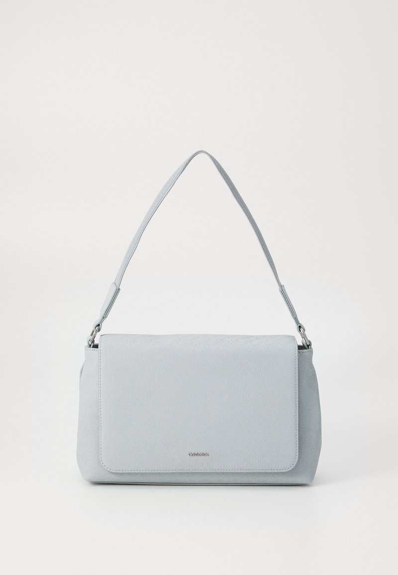 Light gray handbag with a textured finish, adjustable shoulder strap, and magnetic flap closure. Features a subtle brand logo on the front.