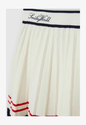 Plisejna bela krila z rdečimi in mornarsko modrimi črtami, z mornarsko modrim trakom na pasu, na katerem je izvezena napis "SmileyWorld". Vidna podrobnost teksturirane tkanine.