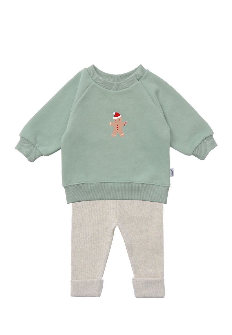 Green sweatshirt with gingerbread man print, paired with light gray ribbed pants, featuring rolled-up cuffs and soft fabric texture.