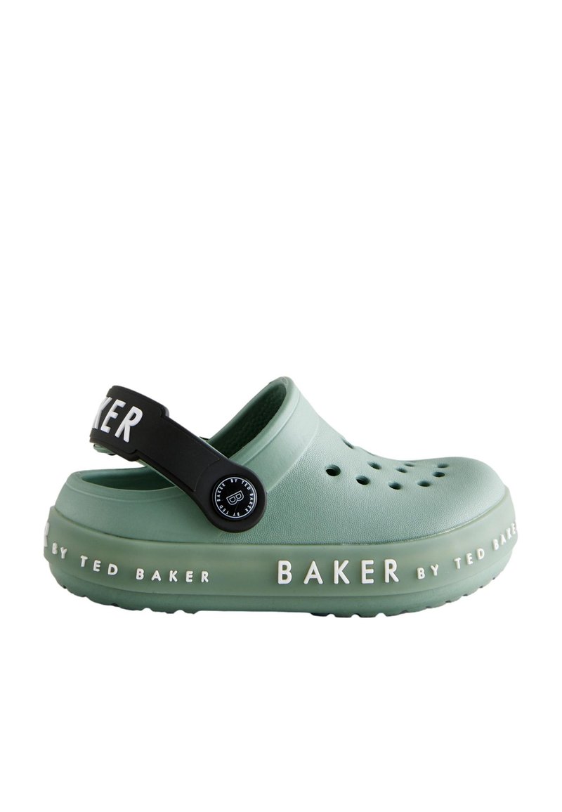 Groene gemodelleerde klompen met perforaties, zwarte band met ronde hardware en contrasterende witte tekst "BAKER by TED BAKER" op de zool.