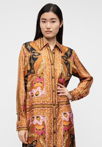 Ilgomis rankovėmis marškinių suknelė oranžinės ir juodos spalvos gėlių raštu, turinti apykaklę, sagutėmis užsegamą priekį ir laisvo kirpimo su sudėtingais raštais.