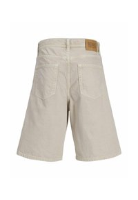 Shorts en denim beige avec deux poches arrière, coupe droite et une étiquette en cuir de marque visible sur la ceinture. Texture lisse, design décontracté.