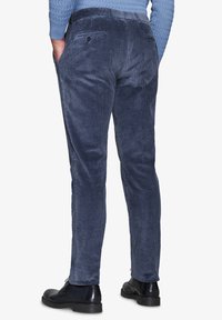 Navyblå cordbukser med en diskret ribbet tekstur, slim fit og baglommer, parret med sorte lædersko.
