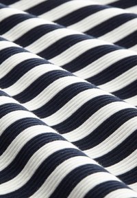 Wellig gestreifter Stoff in abwechselndem Marineblau und Weiß. Strukturiert Oberfläche mit einem gerippten Muster.