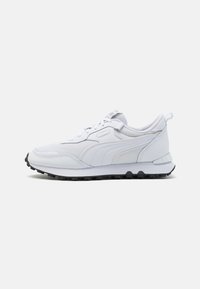 Chaussure de sport blanche avec une tige synthétique lisse et un design en couches, dotée d'une semelle en caoutchouc noire et d'accents texturés.