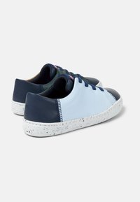 Blue and dark navy leather sneakers with a speckled white sole, rounded toe, and contrasting stitching. Lace-up design, minimalist look.