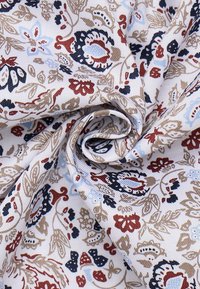 Tessuto bianco attorcigliato in una spirale, con un motivo floreale che presenta fiori e foglie nei toni beige, azzurro chiaro, blu scuro e ruggine.