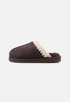 Chausson marron foncé à enfiler avec bordure tricotée crème et doublure intérieure douce et pelucheuse, présenté de côté sur fond blanc.