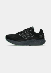 Melna New Balance skriešanas kurpe ar pelēku zoli, "Fresh Foam" amortizāciju un ūdensnecaurlaidīgas "680" modeļa detaļas uz sāniem un mēles.