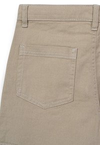 Beiger Denim-Stoff mit einer zurückgesetzten Tasche in spitzem Design, doppelten Nähten in einer helleren Farbe und einer glatten Textur.