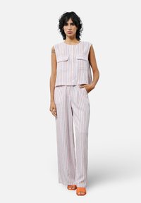 Twee-delige outfit met een mouwloze, gekorte top en wijde broeken. De stof is wit met verticale oranje en blauwe strepen. Heeft twee zakken.