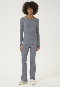 Prugasta majica s dugim rukavima i široke hlače, mornarsko plava i bijela, rastezljiv materijal, čamac izrez, uski kroj s glatkom teksturom.