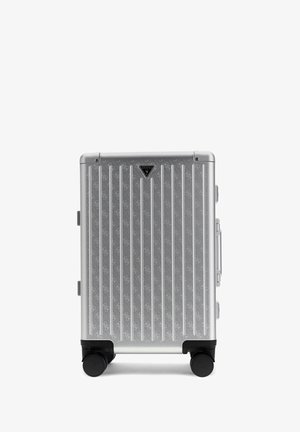 Zilveren harde koffer met verticale ribbels, merklogo bovenaan in het midden en vier zwarte zwenkwielen.
