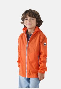 Chaqueta impermeable naranja con cierre de cremallera, puños elásticos, capucha y un parche con logo en la manga izquierda. Material ligero, diseño casual.