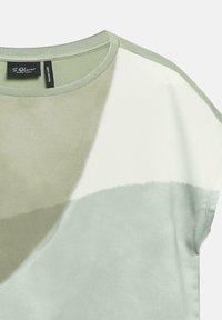 Close-up of a short-sleeve top with a round neck, featuring abstract blocks of beige, white, and light gray colors.