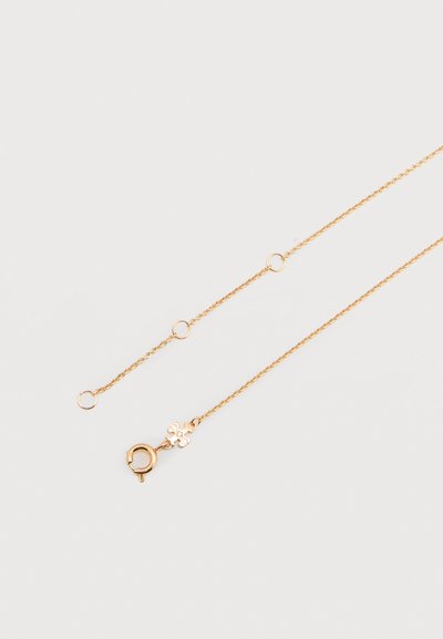 Λεπτό χρυσό κολιέ αλυσίδα με μικρούς κρίκους και κούμπωμα ελατηρίου, διακοσμημένο με ένα διακοσμητικό μοτίβο τετραφυλλιού.