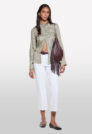 Camicia a maniche lunghe beige con macchie leopardate nere, abbinata a pantaloni bianchi cropped. Accessoriata con una borsa a frange bordeaux scuro e ballerine nere.