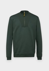 Sudadera de color verde oscuro con un alto cuello, media cremallera con una pestaña amarilla y acentos de canalé en el pecho y los puños. Textura suave.