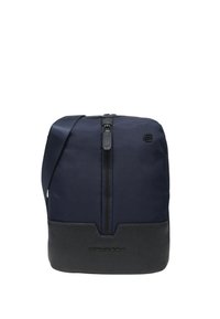 Borsa a tracolla blu navy con parte superiore in tessuto strutturato e base in pelle nera liscia; presenta una cerniera centrale e un dettaglio con il logo.