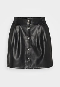 Mini-jupe en cuir noir avec taille élastique, plis et cinq clous en pyramide argentés comme boutons sur le devant. Texture lisse.