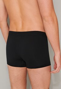 Boxer shorts neri in cotone con una morbida vita. Il tessuto è liscio e aderente, con un design classico e senza loghi visibili.