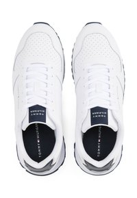 Bílé sportovní boty s perforovaným koženým svrškem, kulatou špičkou, námořnickými akcenty a strukturovanou gumovou podrážkou. Logo "Tommy Hilfiger" na jazyku.