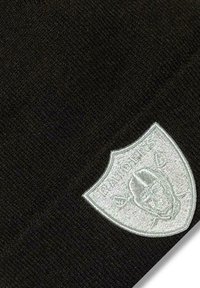 Schwarze Strickmütze mit silbernem, gesticktem Wappen-Logo und einem Design eines Footballspielers, das die glatte Textur und die enganliegende Form betont.