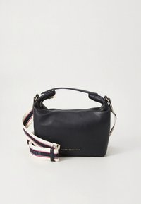 Bolso de cuero azul marino con forma rectangular, con asa superior, correa ajustable y detalle de logo dorado. La correa a rayas añade contraste.