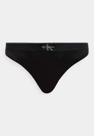 Μαύρο ανδρικό στρινγκ Calvin Klein με ελαστική μέση που φέρει το λογότυπο CK σε γκρι στο κέντρο μπροστά.