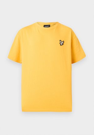 Κίτρινο κοντομάνικο μπλουζάκι με στρογγυλή λαιμόκοψη και μικρό μαύρο και λευκό λογότυπο πουλιού στο αριστερό μέρος του στήθους.