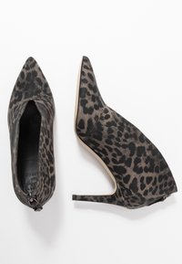 Zapatos de tacón alto con estampado de leopardo en tela negra y marrón, con punta puntiaguda y una silueta elegante con cierre de cremallera en la parte trasera.