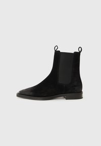 Bottines en suede noir avec un bout pointu, des panneaux latéraux élastiques et des languettes de traction ; texture lisse et petit talon carré.