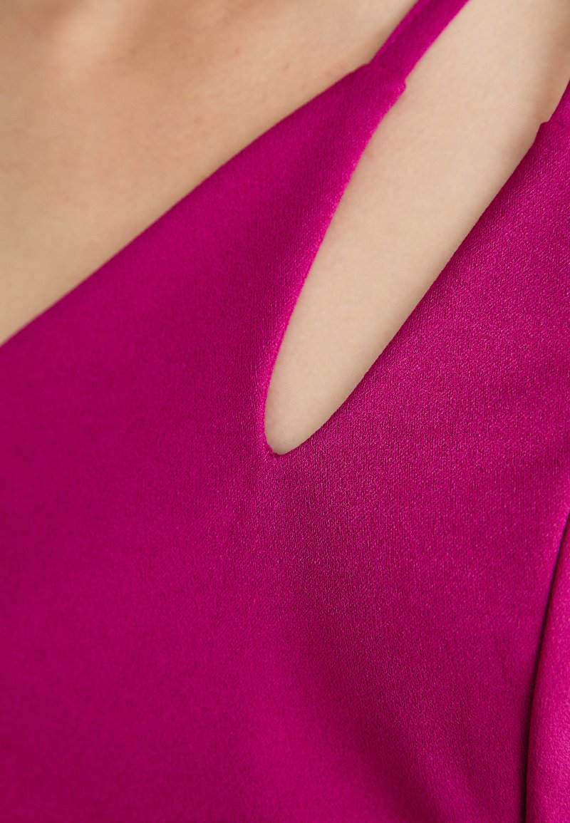 Vestido fucsia con un escote en V profundo y un detalle de corte, hecho de una tela de textura suave, con tirantes finos y una forma ajustada.