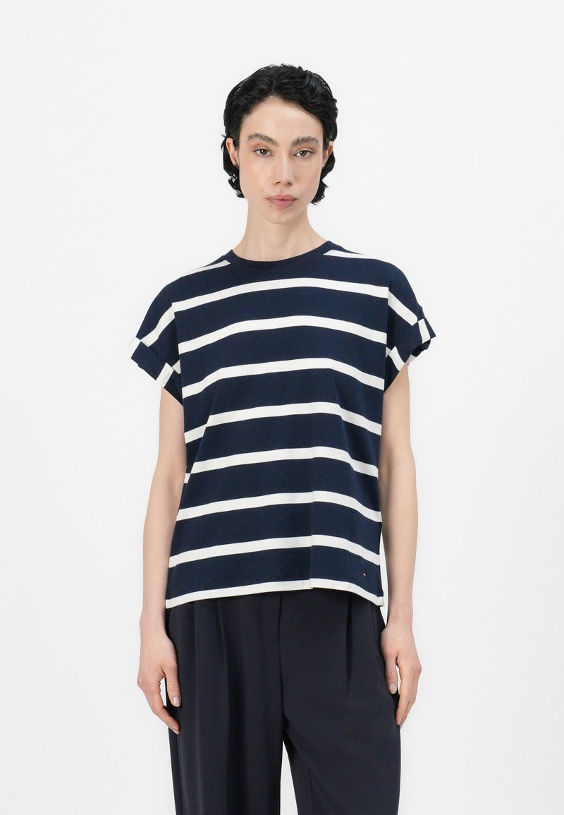 Marineblå og hvit striped kortermet t-skjorte med avslappet passform, rund hals, og rullede ermer, laget av myk stoff.