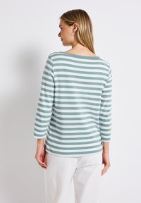 Gestreepte longsleeve top in lichtblauw en wit, met een ronde hals en zachte stof. Beschikt over ¾ mouwen en een iets gebogen zoom.