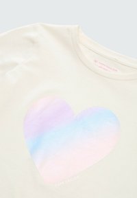 Krämfärgad t-shirt med en stor iriserande hjärt-grafik. Mjuk tyg med en slät yta och rund halsringning.