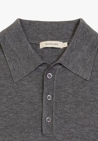 Graues Poloshirt aus weichem Material, mit klassischem Kragen, vier Knöpfen mit lila Akzenten und einem Etikett mit der Aufschrift "GIANNILUPO L."