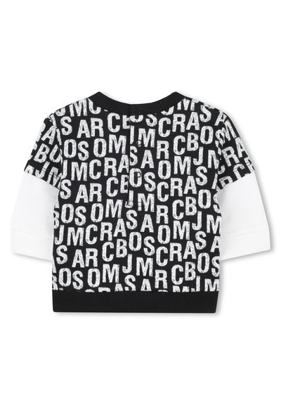 Maglione a maniche lunghe in bianco e nero, con un taglio cropped e grandi lettere in blocco di dimensioni varie, arricchito da maniche bianche a contrasto e una vita a coste nera.