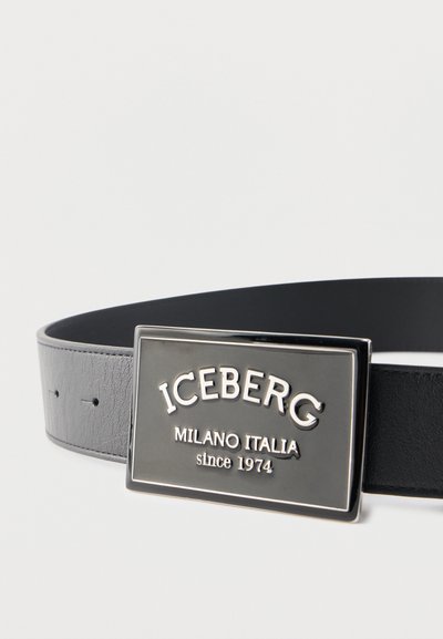 Μαύρη δερμάτινη ζώνη με ορθογώνια μεταλλική αγκράφα χαραγμένη με το "ICEBERG MILANO ITALIA since 1974" σε απλό φόντο.