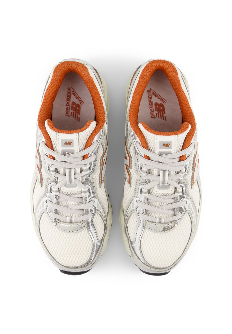 Zapatillas de malla blanca con acentos naranjas y plateados, que presentan una superficie texturizada, puntera redonda y cordones ajustables. Logo de la marca visible.