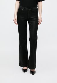 Fekete, bővülő szárú nadrágok, sima bőrből, testhezálló derékkal és klasszikus, ötzsebes kialakítással, minimális varrással.