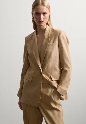 Beige Leinenblazer mit taillierter Passform, ausgestattet mit Reverskragen, zwei Fronttaschen und einem Ein-Knopf-Verschluss. Glatte Textur und minimales Design.