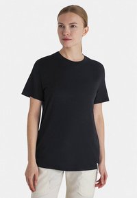 Czarny t-shirt z krótkim rękawem wykonany z miękkiej bawełny. Posiada okrągły dekolt oraz luźny krój, z minimalistycznym designem i bez wzorów.